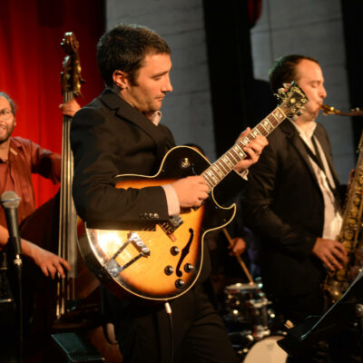 trio jazz à lyon avec guitare, saxophone et contrebasse, pendant un concert au péristyle de l'opéra